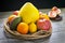 Fruits are tied with a decorative palm rope and lie on a gray rustic tabletop against a dark wall