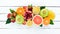 Fruits on a white wooden background. Mango, melon, pomegranate, strawberry, banana. Top view.