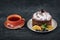 Fruity cake in plate with slices of dried orange and a cup of tea