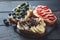 Fruity vegetarian toasts for breakfast on dark background. Bread slices with ricotta, berries, banana, chocolate and seeds