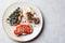 Fruity vegetarian toasts for breakfast on gray background. Bread slices with ricotta, berries, banana, chocolate and seeds