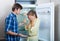 Frustraited starving female and man near fridge without any food