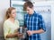 Frustraited starving female and man near fridge without any food