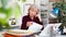 Frustrated aged female entrepreneur sitting at office desk with papers