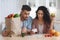 Frustrated Arab Spouses Sitting In Kitchen Checking Bills After Grocery Shopping