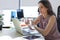 Frustrated business woman looking exhausted while sitting at her working place and carrying her glasses in hand