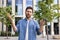 Frustrated businessman with beard having troubles using smartphone outside office