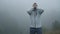 Frustrated depressed man in depression grabs his head standing alone in the fog