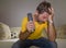 Frustrated football fan in intense emotion - home portrait of young dejected and sad man watching soccer game on television at