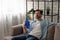 Frustrated guy recline on sofa cool down with hand fan