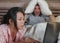 Frustrated husband moody in bed ignored by his workaholic Asian wife or internet social media addict girlfriend using laptop in