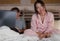 Frustrated Korean woman in bed ignored by workaholic husband or internet social media addict boyfriend networking with laptop in