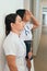 Frustrated Latina nurses leaning against hospital wall
