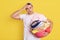 Frustrated overworked man posing with basin full of dirty clothes, having much home duties, stands with laundry basket, male