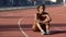 Frustrated with results biracial sportswoman lonely sitting in middle of track