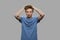 Frustrated teen boy on gray background.