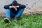 Frustrated teenage boy sitting near a crumbling wall at the correctional institute