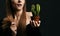 Frustrated woman with long silky straight hair in black body holding cactus plant in pot and comparing with split ends