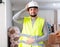 Frustrated worker in yellow vest and hard hat is dissatisfied with the way walls are plastered