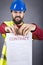 Frustrated young engineer with hardhat and reflective vest tear