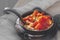 Fry in a frying pan sliced juicy orange pumpkin with wheat cereal and with country style spices in a clay pot. The concept of
