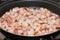 Frying bacon pieces in a pan with hot oil