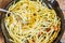 Frying pan with bucatini pasta with herbs and cheese