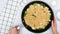 Frying pan with cauliflower and broccoli topped with Alfredo sauce and bread crumbs close up in woman hands.