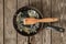 Frying pan with food leftovers on a wooden table after breakfast in the kitchen