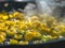 A frying pan sizzles with cooked artichokes, releasing aromatic steam into the air