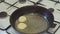 Frying pan on the stove with dough, close-up