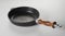 Frying pan with wooden handle on table