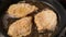 Frying pork meat coated with breadcrumbs in a pan