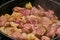 Frying the raw beef and the onions in a cauldron to prepare the Hungarian cauldron goulash