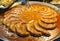 Frying rounded sausages in huge bowl