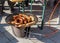 Frying sausages and tasty pieces of lard on an outdoor barbecue propane disc cooker