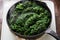 Frying thawed frozen spinach on iron skillet