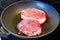 Frying two piece of meat in pan on electric range