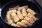 Frying Vietnamese spring rolls in black pan