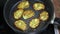 Frying zucchini pancakes in a round pan on an electric stove, cooking baking