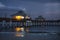 The Ft.Myers pier at night with a warm, yellow light reflecting in the water.