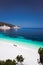 Fteri beach Kefalonia, Greece. Family under umbrella on pebble beach. Clear blue azure emerald sea water in lagoon