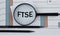 FTSE - acronym on a graph with pencils and a magnifying glass