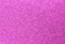 Fuchsia glitter background in reflective and shimmering material