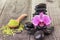 Fuchsia Moth orchid and black stones on weathered deck