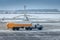 fuel tanker truck rides on the taxiway at the airport against the background of a helicopter at winter time