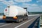 Fuel truck rides on highway, white blank cistern for oil, rear view, one object on road