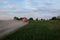 A fuel truck rushing along a dirt road leaving behind clouds of dust