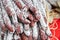 Fuet. Heap of dry-cured  sausages with white mold on the counter of the farmers market. Meat products