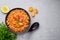 Ful Medames or Fava Beans in black bowl at grey backdrop. Foul Mudammas is a Egyptiancuisine breakfast dish